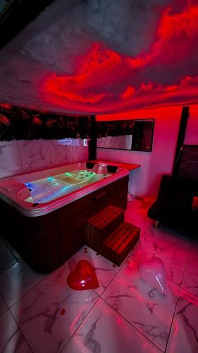 Cette chambre dispose d'un bain à remous avec éclairage rouge. dans l'établissement Appartement jacuzzi - Love Room, à Lyon
