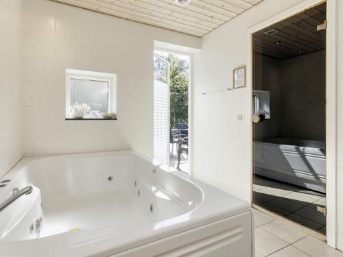 a large white bath tub in a room with a window at 10 person holiday home in Væggerløse-By Traum in Marielyst