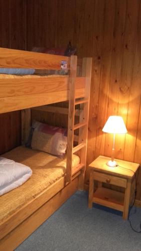 een slaapkamer met twee stapelbedden en een lamp bij Chalet L'Eider in Bolquere Pyrenees 2000