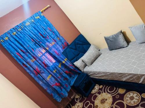 a bedroom with a bed with a blue curtain at gift for mom in El Jadida