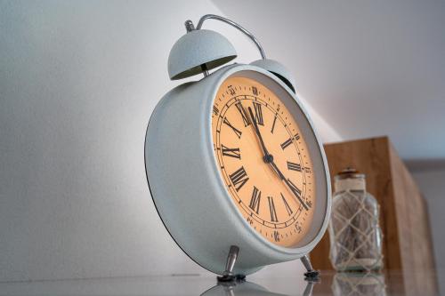 a clock sitting on a table next to a bottle at Residenz Panorama - Blatten bei Naters VS in Blatten bei Naters