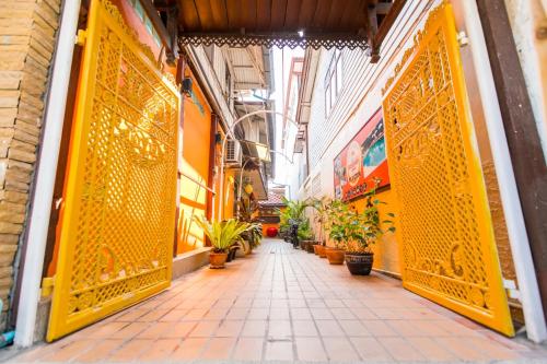 an alley with yellow doors and potted plants at MANDARIN LODGE by victor in Hua Hin
