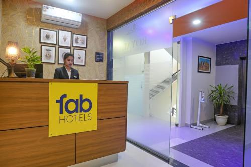 a man standing at a reception desk in a lobby at FabHotel Royal International - Nr Mumbai International Airport in Mumbai