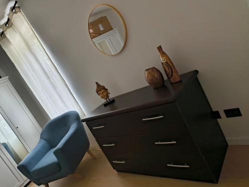 a blue chair sitting next to a dresser with a mirror at Girasole Casa Vacanza in Stradella