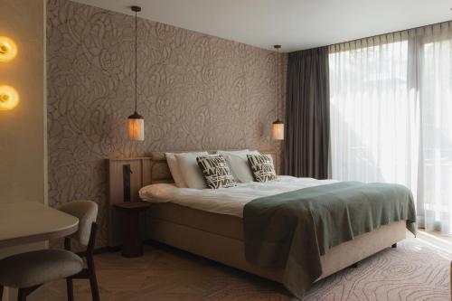 a bedroom with a bed and a window at Wellnesshotel Thermae 2000 in Valkenburg