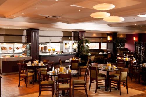 a restaurant with tables and chairs and a bar at Leonardo Inn Glasgow West End in Glasgow