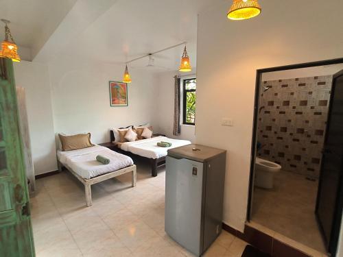 a living room with a couch and a bed and a table at NAMAKA, Morjim Beach-Ashwem Beach 5 min in Morjim