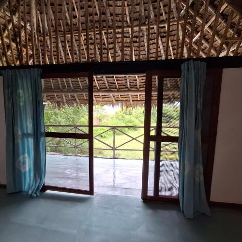 an open window with a view of a yard at Kipepeo Beach and Village in Dar es Salaam