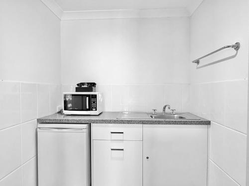 a kitchen with a sink and a microwave at Albury Paddlesteamer in Albury