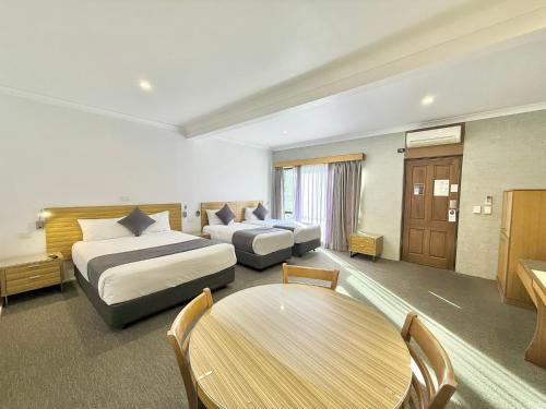 a hotel room with two beds and a table at Albury Paddlesteamer in Albury