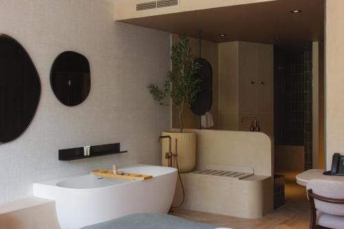 a bathroom with a white tub and a sink at Wellnesshotel Thermae 2000 in Valkenburg