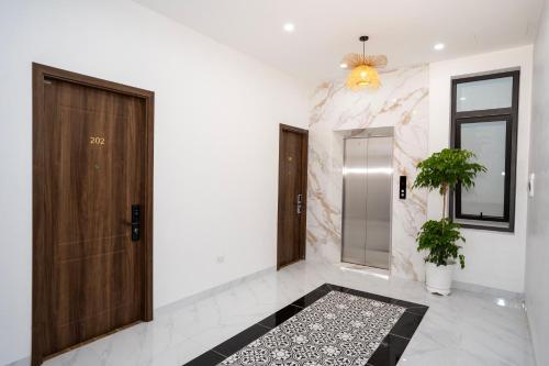a hallway with a wooden door and a rug at Le Grande TamCoc Retreat in Ninh Binh