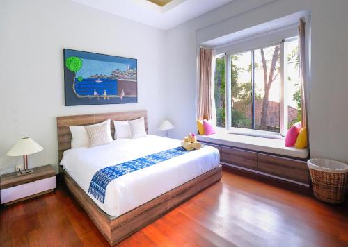 a bedroom with a large bed and a window at La Quoriena Botanical Villa & Cafe' in Labuan Bajo