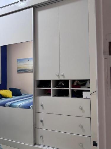 Apartamento في بيليم: غرفة نوم بها سرير وخزانة ملابس بيضاء