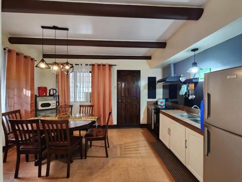 eine Küche und ein Esszimmer mit Tisch und Stühlen in der Unterkunft The Wood Cabin Home Tagaytay with Billiards and Minipool 10mins from Skyranch in Galicias