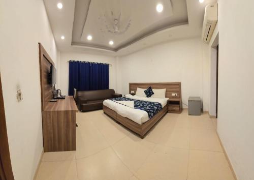a bedroom with a bed and a couch at The Maple Stays in Gurgaon