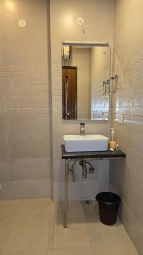 a bathroom with a sink and a mirror at The Maple Stays in Gurgaon