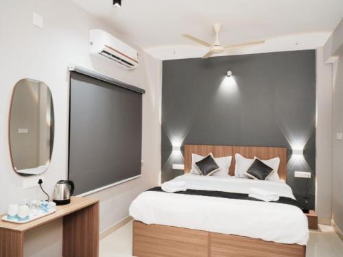 une chambre avec un grand lit et un miroir dans l'établissement Elegant Residency, à Coimbatore
