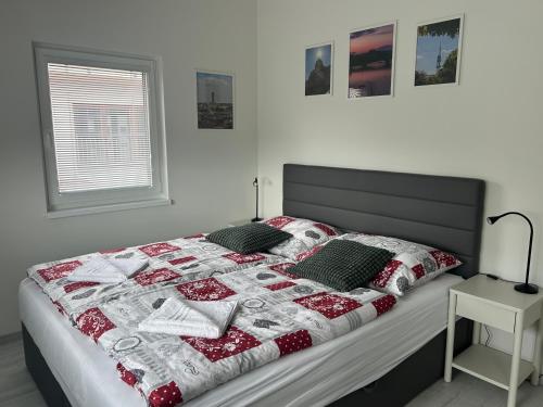 a bed with a red and white quilt on it at Holiday Home Prague Šeberov in Prague