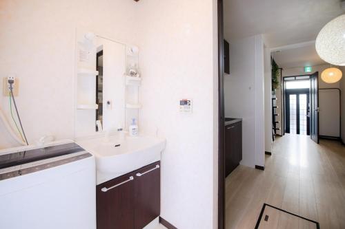 a white bathroom with a sink and a mirror at Rakuyodo Higahikujo in Kyoto