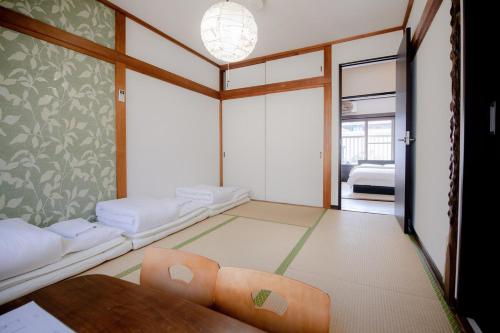 a room with two beds and a table in it at Rakuyodo Higahikujo in Kyoto