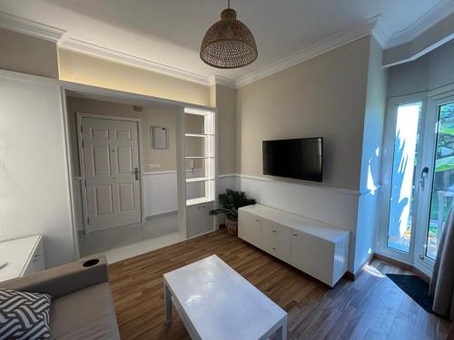 a living room with a couch and a tv at Apartment with nice garden in Sheikh Zayed