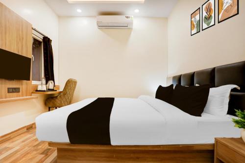 a bedroom with a black and white bed and a desk at Super Townhouse Oak AIIMS Walmi Govindpur in Patna