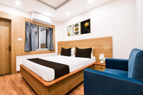 a bedroom with a bed and a blue chair at Palette Shree Jagannath Puri in Puri