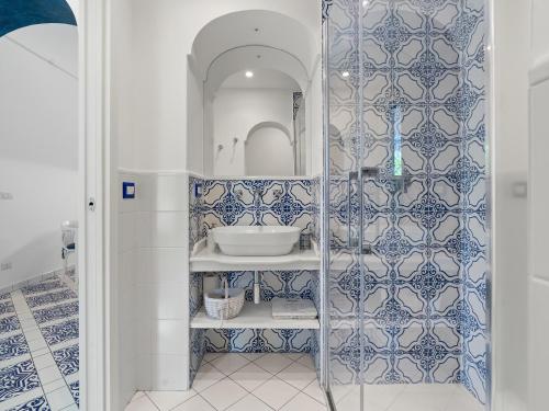 a bathroom with blue and white tiles on the wall at Maison Don Rafe' in Positano