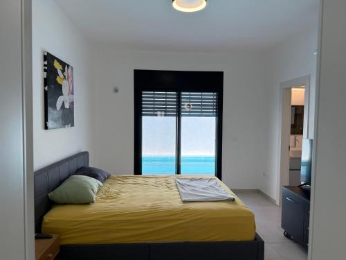 a bedroom with a bed with a view of the ocean at Villa In The Deseret - Villa 219 in Beʼer Ora