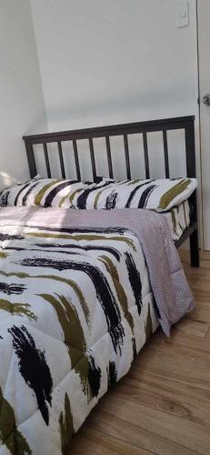 a bed with a comforter on it in a room at Naga City Stylish Condo in Naga