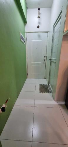 a hallway with a white door and a green wall at Naga City Stylish Condo in Naga