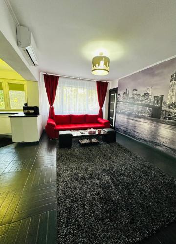 a living room with a red couch and a large window at 17 Apartment in Bucharest