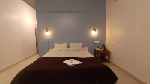 a bedroom with a large bed with a black blanket at Happy Land in Varkala