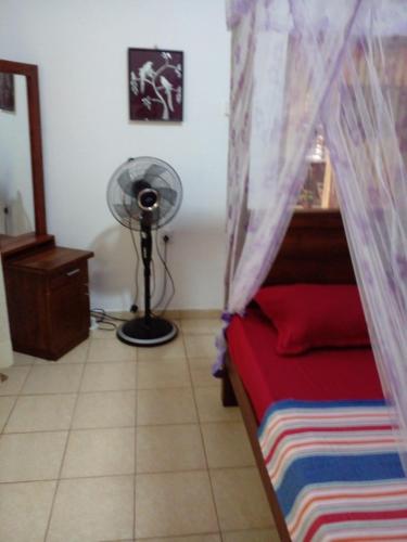 una camera da letto con un letto e un ventilatore in una stanza di Gem Villa a Weligama