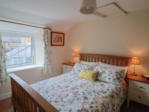 a bedroom with a bed and a window at Vine Cottage in Burton Bradstock