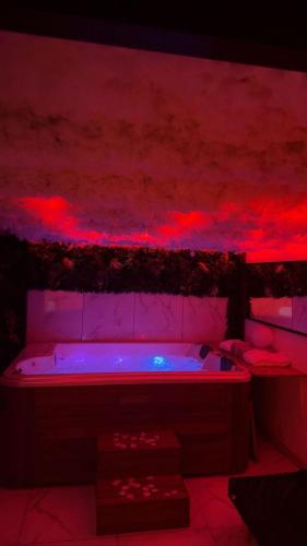 a room with a hot tub with red and blue lights at Appartement jacuzzi - Love Room in Lyon