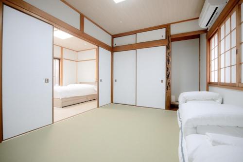 a bedroom with two beds and a mirror at GUAGUA house in Kyoto