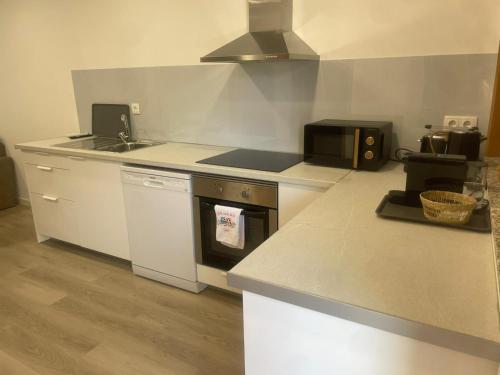 a kitchen with a stove top oven and a sink at Gerês View in Geres