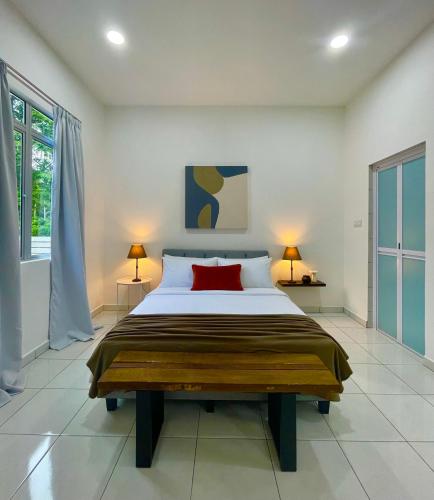 a bedroom with a large bed with a red pillow at Bloc Guesthouse in Pantai Cenang
