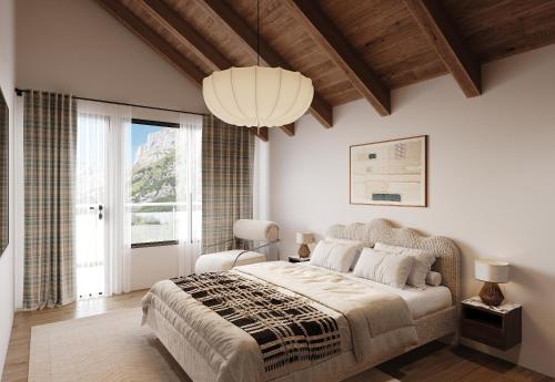a bedroom with a large bed and a chandelier at Tarbey Alpine Apartment Leukerbad in Leukerbad