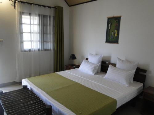 ein Schlafzimmer mit einem großen Bett mit weißer Bettwäsche und einem Fenster in der Unterkunft HOTEL H1 ISALO in Ranohira