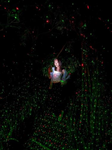 a girl is sitting on a swing at night at Napahong Treehouse forest camp in Ban Pa Ha