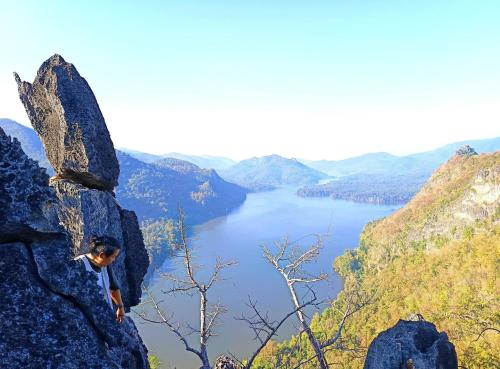 a man on a rock overlooking a lake at Napahong Treehouse forest camp in Ban Pa Ha