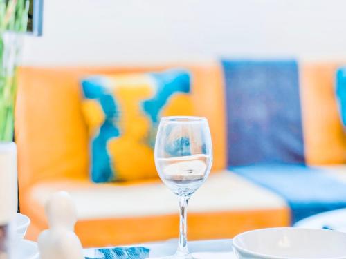 a glass of wine sitting on a table with a couch at Elegant 1 bed flat, Sleeps 4, Free parking, Pet friendly, Pudsey, Leeds in Pudsey
