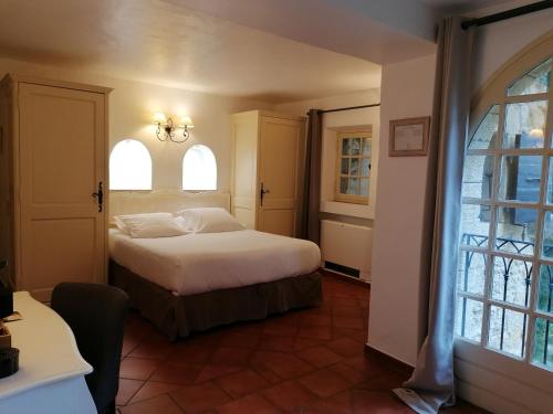 a bedroom with a bed and two windows at Garrigae Abbaye de Sainte Croix in Salon-de-Provence