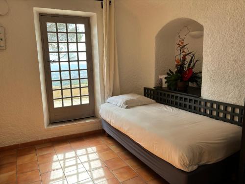 a bedroom with a bed in front of a window at Garrigae Abbaye de Sainte Croix in Salon-de-Provence