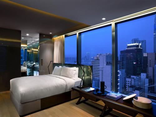 una camera con un grande letto e una grande finestra di 99 Bonham a Hong Kong