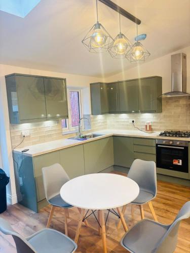 a kitchen with a white table and chairs at Royal Wharf Inn in London