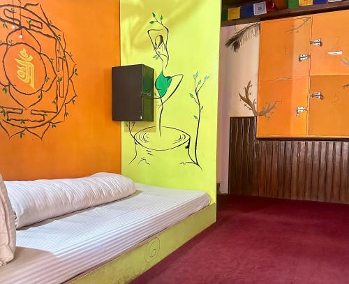 a room with a bed with a painting on the wall at Yog Hostel- Rooftop Yoga & Backpacker Social Stay in Thamel, Kathamndu in Kathmandu